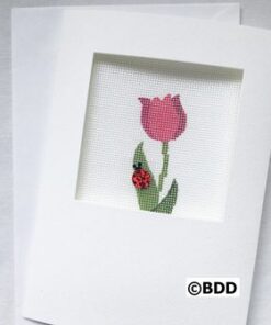 A cross stitch picture of a flower and a ladybug.