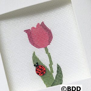 A cross stitch picture of a red flower and a ladybug.