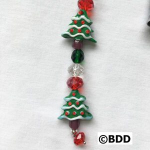 A close up of a bead with christmas trees