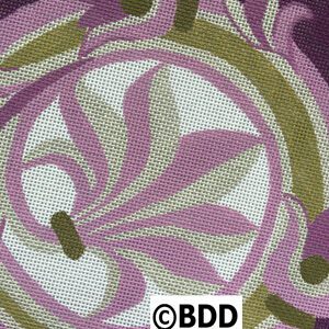 A close up of the fabric with purple and green designs.