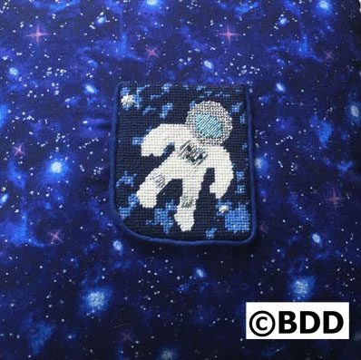 A patch of space suit on the back of a blue and white background.