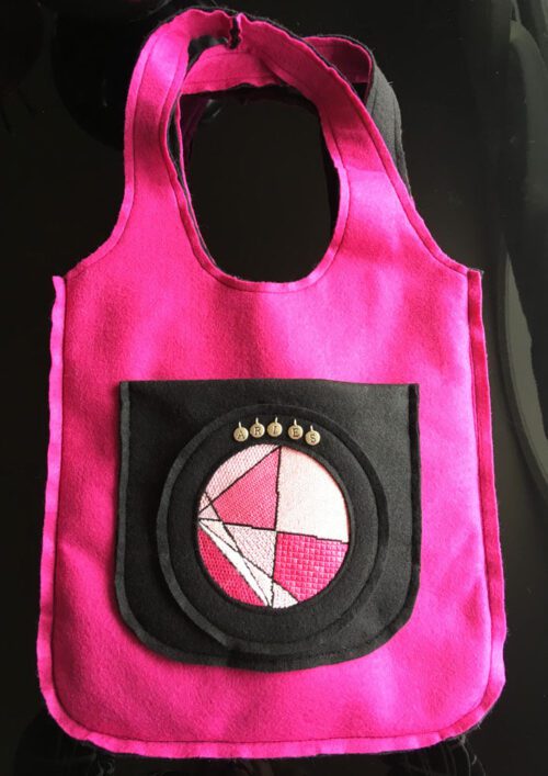 A pink bag with a black pocket on it