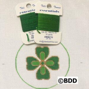 A green cross stitch kit sitting on top of a white background.