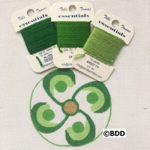 A green circle with four different colors of thread.