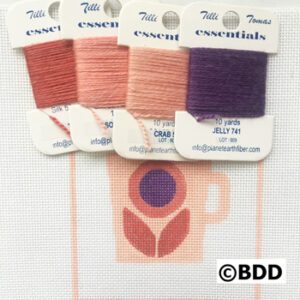 A set of four different colors of thread.