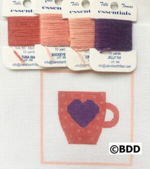 A red cup with purple heart on it and four different colors of thread.