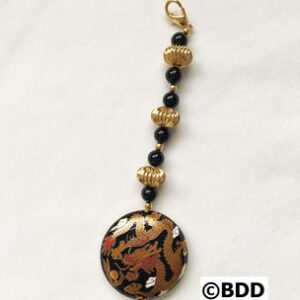 A black and gold bead necklace with a brown pendant.