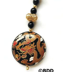 A black and gold dragon necklace with beads.