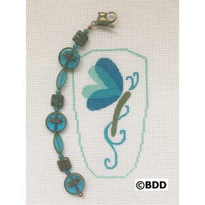 A blue butterfly is on the side of a cross stitch pattern.