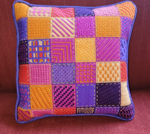 A colorful pillow with a patchwork design on it.