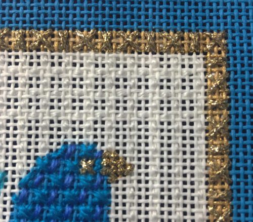 A close up of the blue bird on a cross stitch pattern