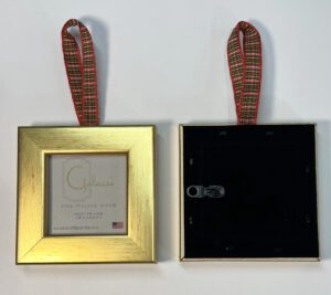 A gold frame with a red ribbon hanging from it.