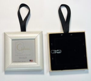 A picture frame hanging on a black ribbon.