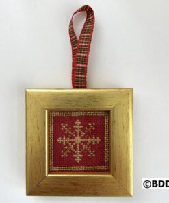 A gold frame with a red and white snowflake ornament hanging on the side.