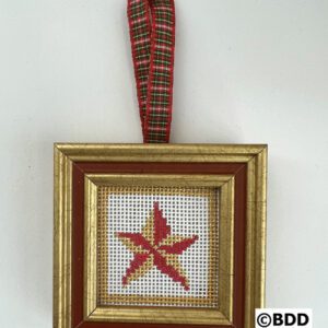 A cross stitch ornament hanging on the wall.