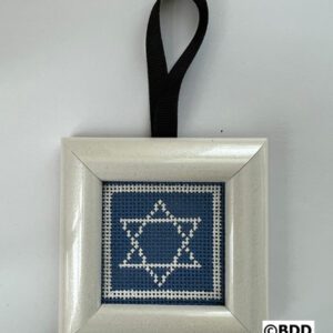 A cross stitch ornament hanging on a black ribbon.