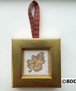 A cross stitch ornament hanging on a gold frame.
