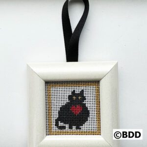 A black cat with red heart on it's back.