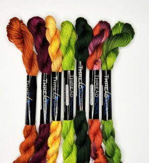 A group of seven skeins of yarn in different colors.