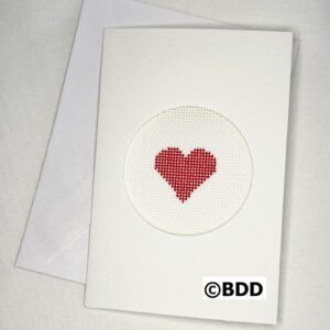 A white card with a red heart stitched on it.