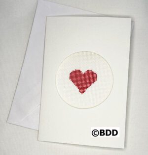 A white card with a red heart stitched on it.