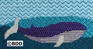 Needlepoint whale in ocean scene.
