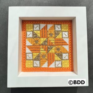 A picture of the frame that is made with cross stitch.