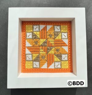 A picture of the frame that is made with cross stitch.