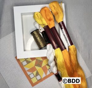 A group of yellow and brown yarn in a white box.