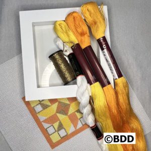 A group of yellow and brown yarn in a white box.