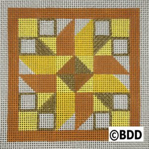 A square quilt block with a yellow star on it.