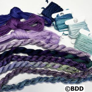 A group of different colored yarn and thread.