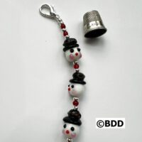 A keychain with three faces and a thimble.