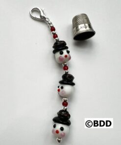 A keychain with three faces and a thimble.
