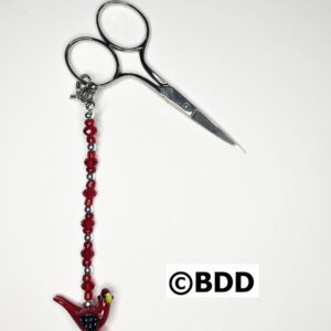 A pair of scissors with a red bird on it.