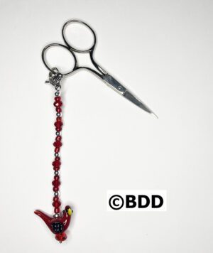 A pair of scissors with a red bird on it.